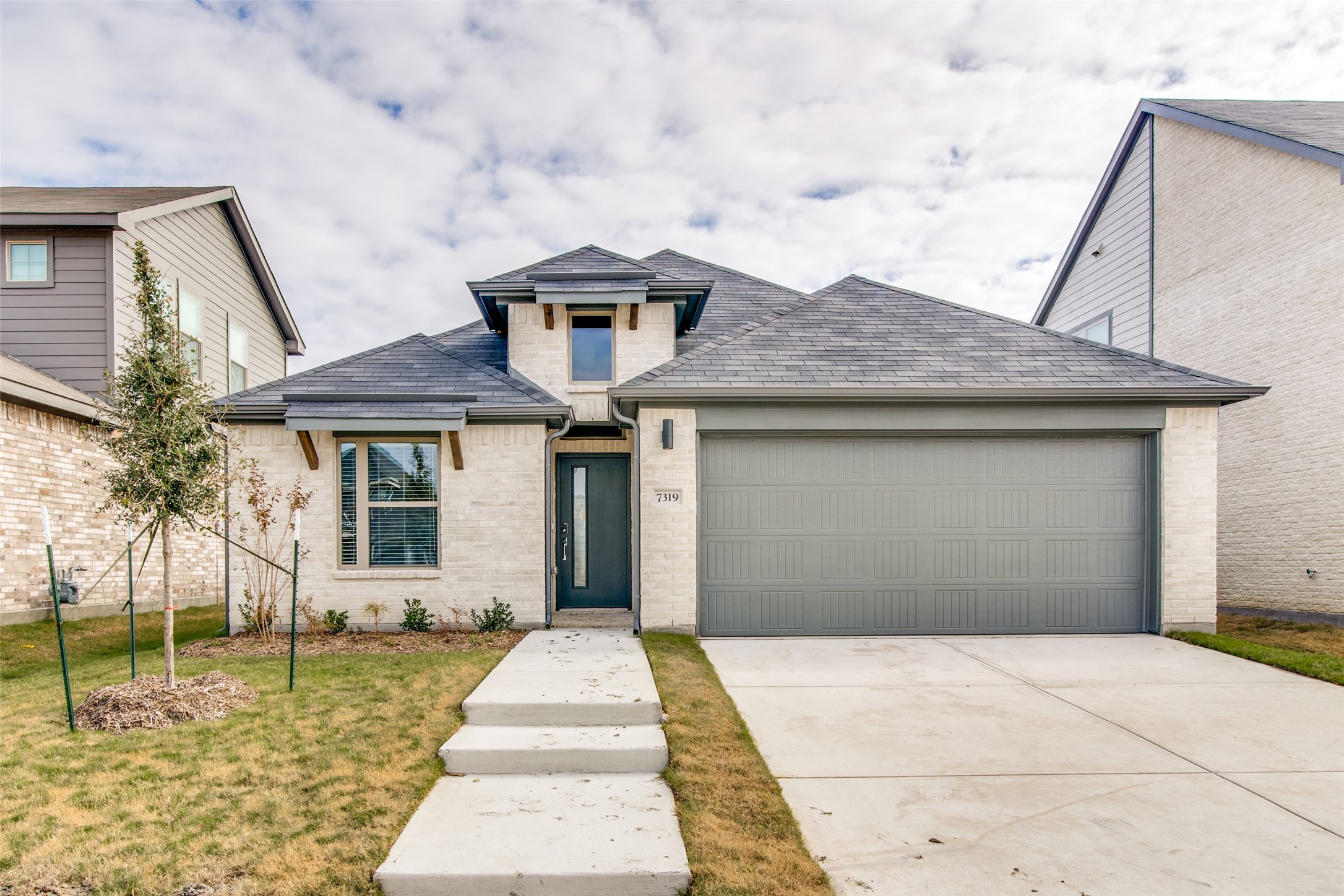 View of front facade with a front lawn and a garage